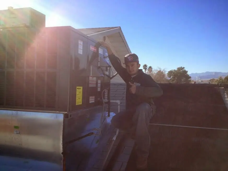HVAC technician performing AC Tune-Up on a rooftop unit in Prairie Grove